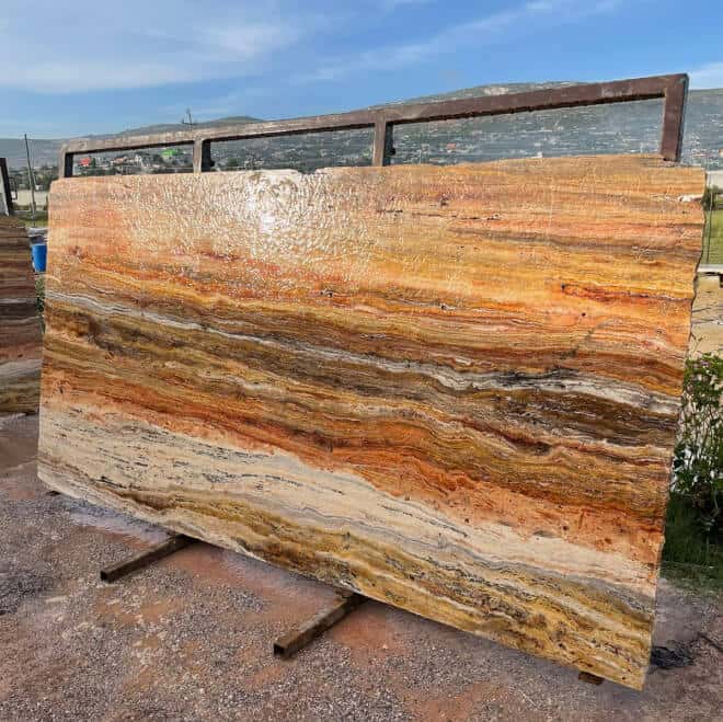 foto horizontal de una pieza grande de piedra natural recostada en una estrcutura de metal